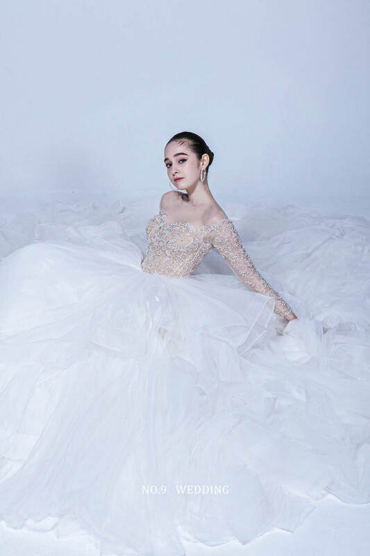第九大道婚紗 台北 COUTURE BRIDAL 白色長袖透膚蕾絲露背白紗，新娘背影展現優雅深V美背與加長拖尾婚紗
